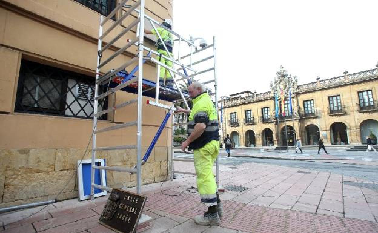 Dos operarios retirando la placa de Juan Benito Argüelles para volver a colocar la del general Yagüe. 