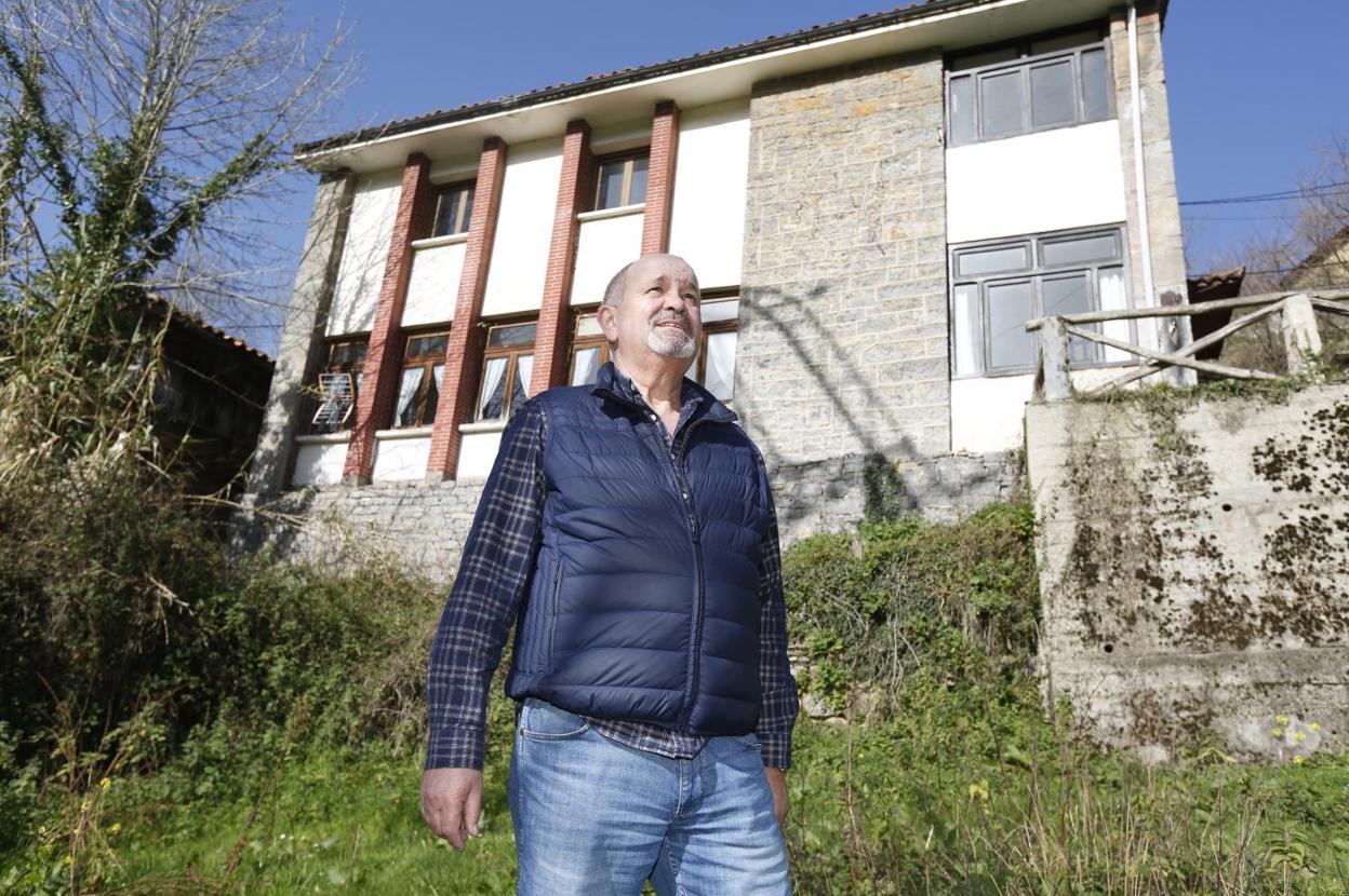 Colás Fernández, ante las escuelas cerradas del pueblo. A la derecha, observando la aldea, ya sin habitantes. 