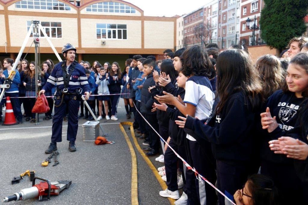 La Brigada Minera ha acudido este jueves al Colegio Nazaret de Oviedo para mostrar a los alumnos el trabajo que realizan. Los miembros del cuerpo simularon un descenso en tirolina con la colaboración de uno de los estudiantes.