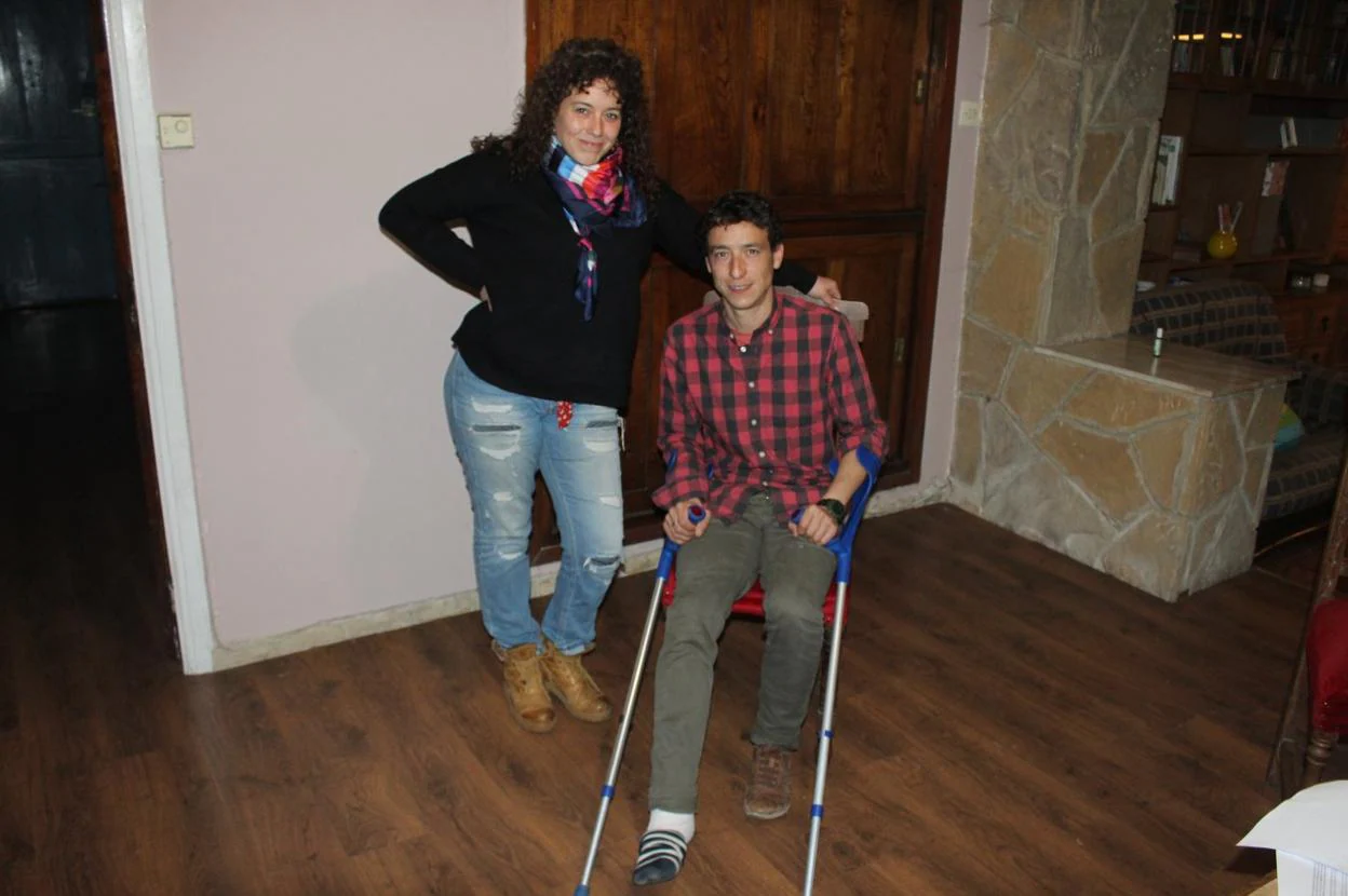 David Puertas, con el pie vendado y con muletas, junto a su pareja, Lorena Veigas, en su casa de Oles. 