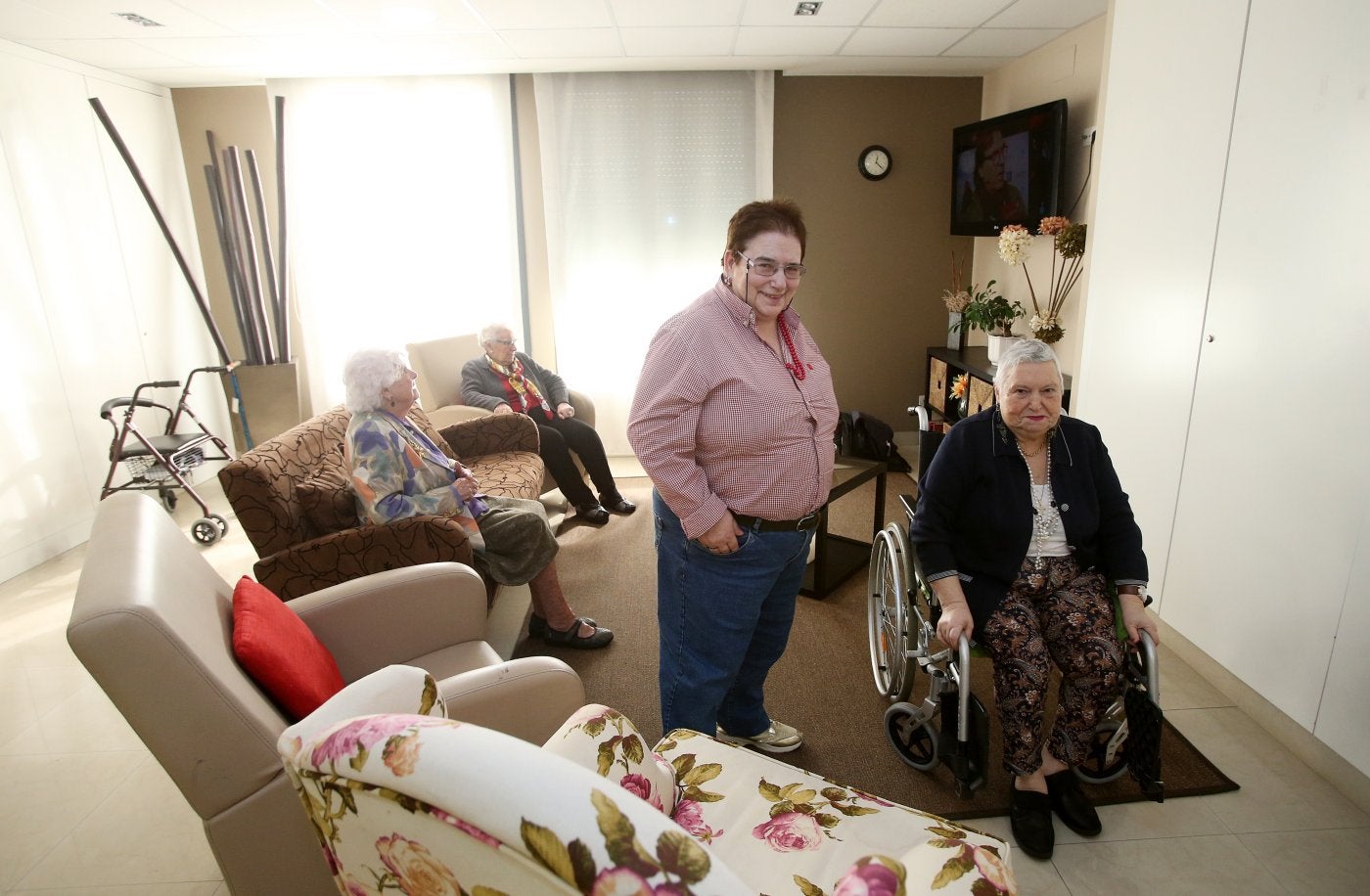 Cuqui y María Esperanza, en primera fila, en una de las salas de Ovida, en Oviedo. Detrás, Pilar y Valentina ven un rato la televisión. 