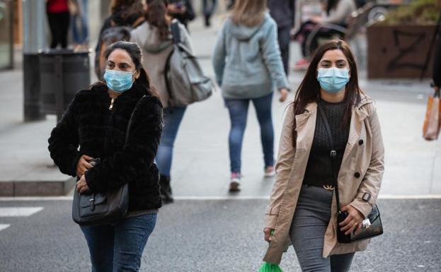 Dos mujeres con mascarillas caminan por Barcelona.