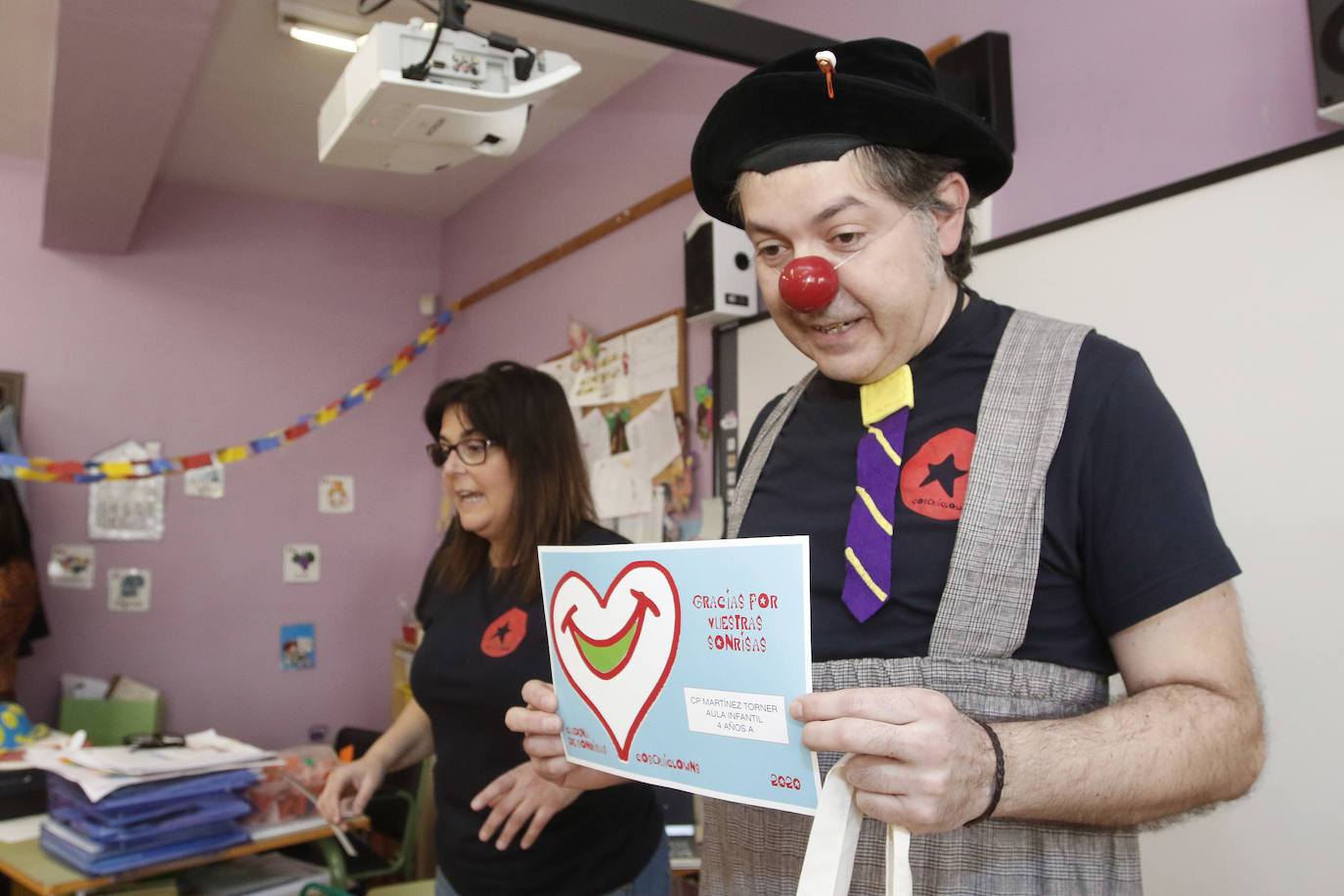 Cosquiclowns ha visitado el colegio Martínez Torner de Gijón ya allí sus payasos Natalia Ablanedo, 'Serpentina', y Manuel Fueyo, 'Monolito', implicaron a los pequeños de segundo de Infantil, para colorear tarjetas de ánimo que llegarán a los niños de la planta de Pediatría del Hospital de Cabueñes.