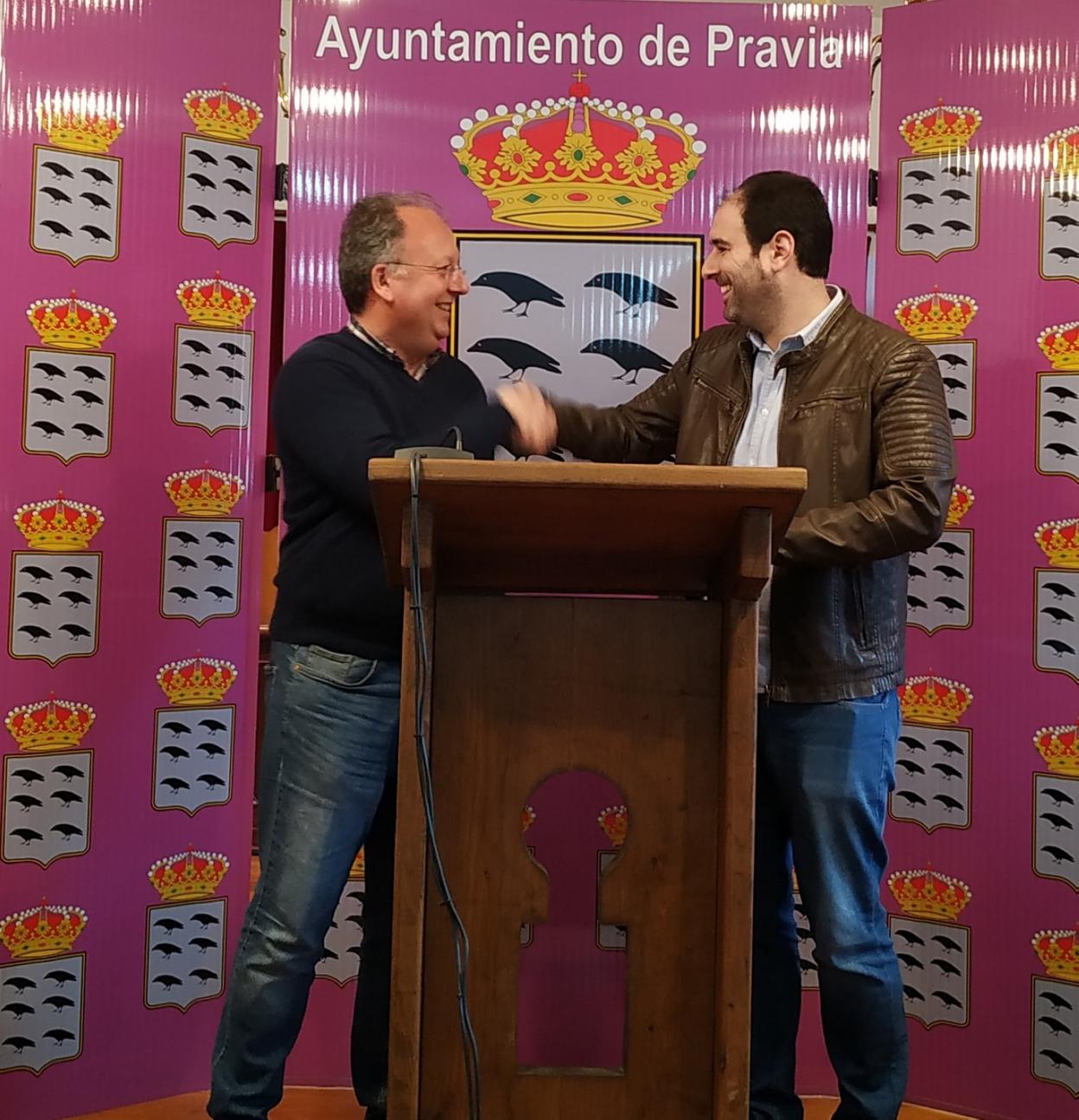 El presidente de la Asociación Astarte y el alcalde de Pravia estrechan la mano tras la firma del convenio. 