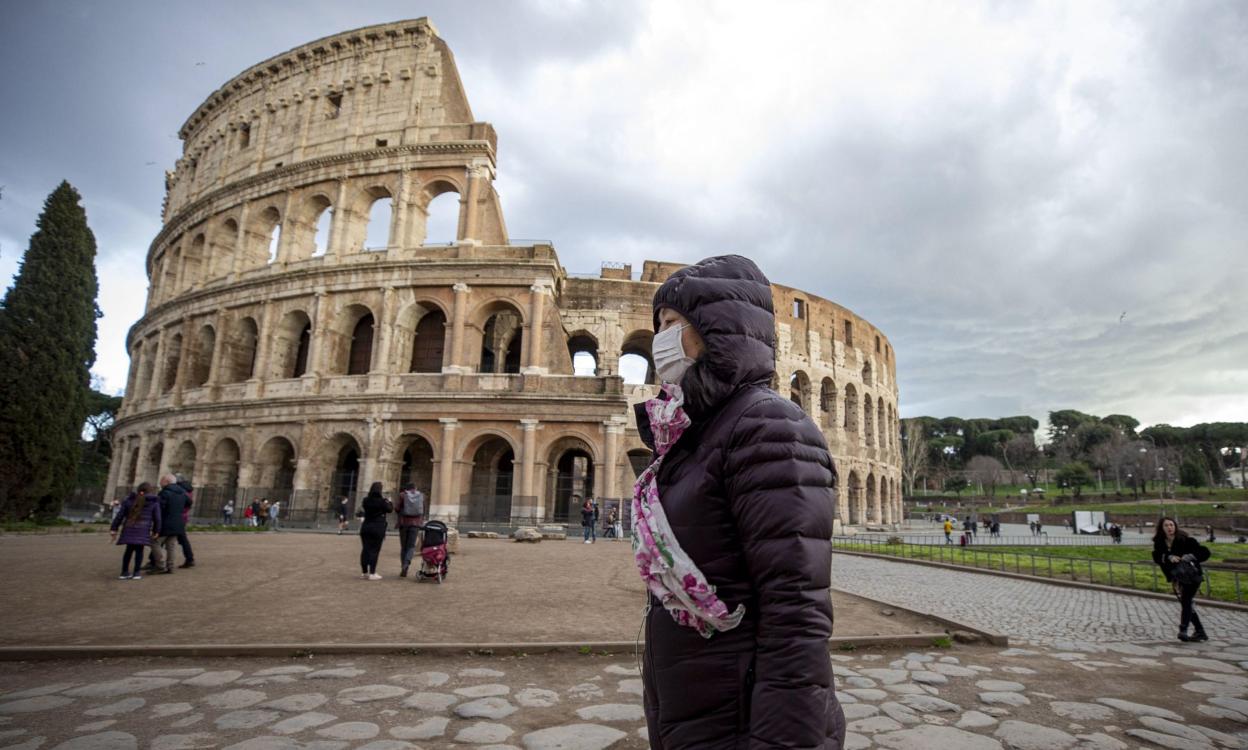 Una turista con máscara, frente al Coliseo romano. 