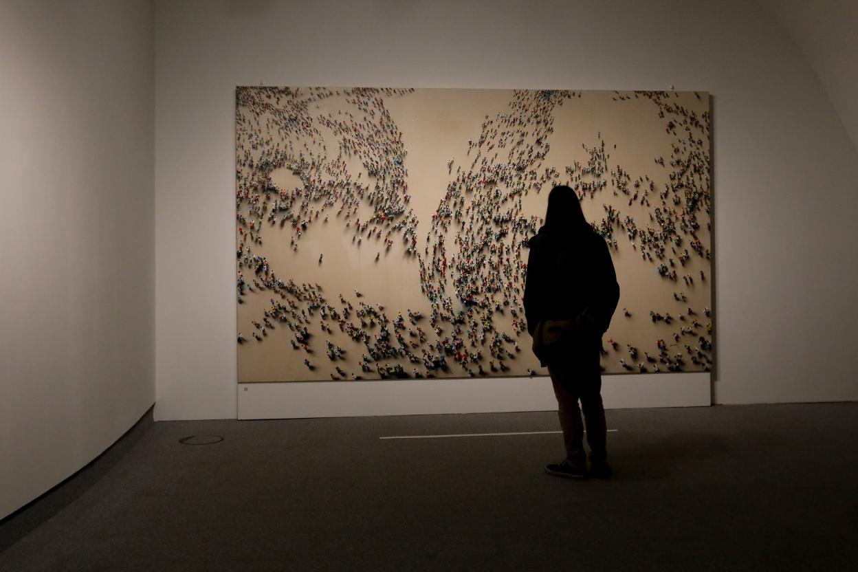 Una mujer observa una de las obras de la muestra de los Genovés. 