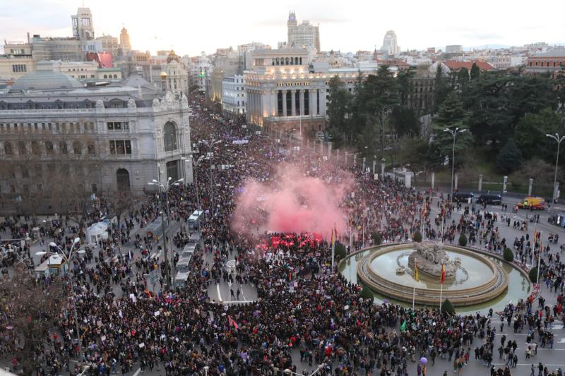 Manifestantes encienden una bengala en la manifestación del 8-M en Madrid.