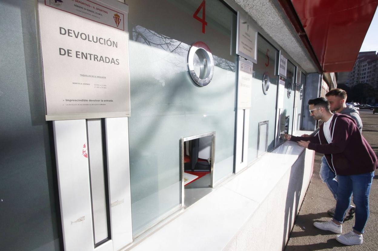 Dos aficionados, ayer por la tarde, delante de las taquillas de El Molinón, donde el club comenzó a devolver el dinero de las entradas.