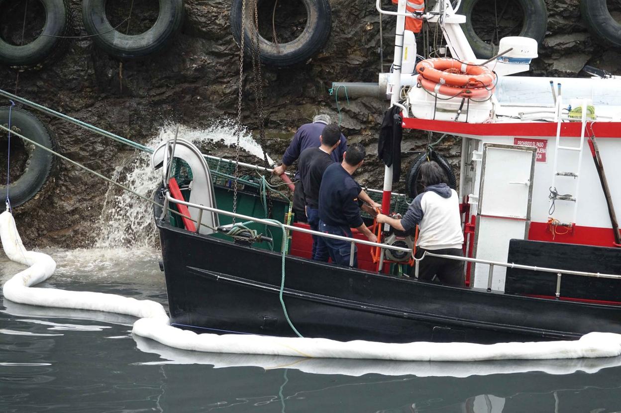 Personal de J&K y del puerto, junto con Salvamento Marítimo, achican el agua del interior del barco.