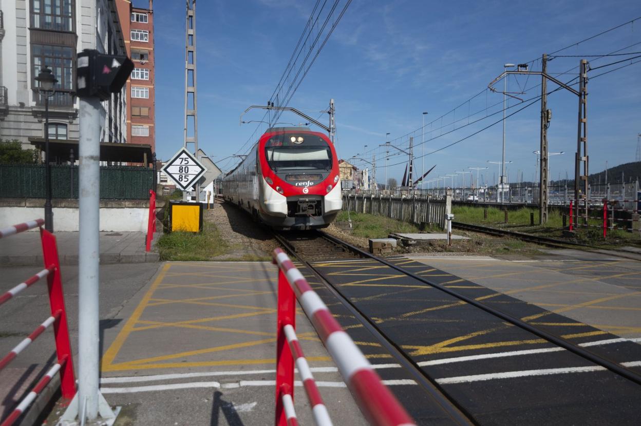 Un tren de cercanías se aproxima al paso a nivel de Larrañaga, en Avilés. 