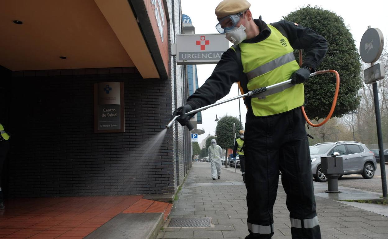 Un miembro de l aUME realiza tareas de desinfección en un centro de salud de Gijón.