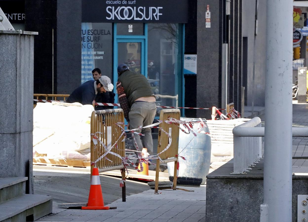 Unos operarios trabajan en una obra en Gijón. 