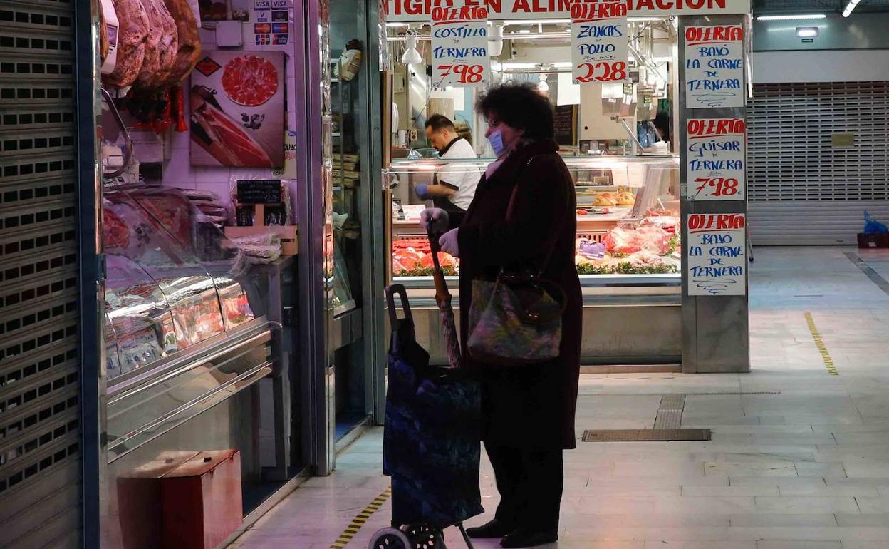 Una mujer con mascarilla acude a la compra en el Mercado dedl Sur de Gijón.