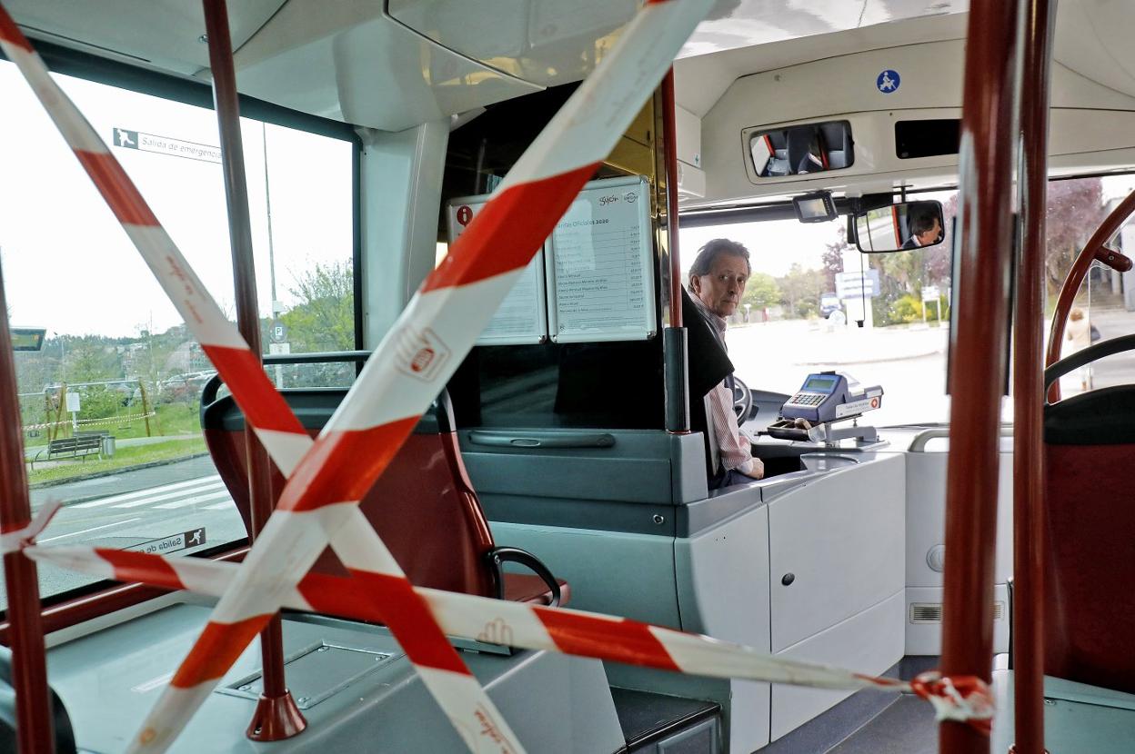 Un conductor de EMTUSA protegido por la distancia de seguridad.Arriba, un policía sube al bus durante un retén de seguridad. 