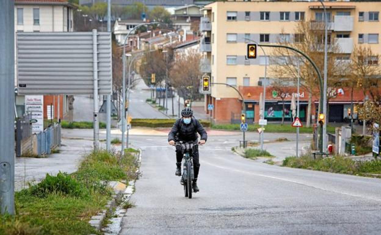 Un ciclista protegido por una mascarilla. 