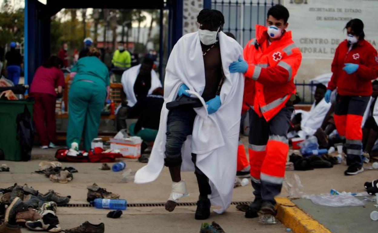 Personal de Cruz Roja atienden a las personas que lograron saltar la valla.