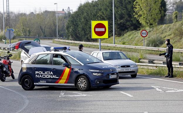 Efectivos de Policía Nacional durante un control de carretera establecido en Gijón para vigilar el cumplimiento del estado de alarma.