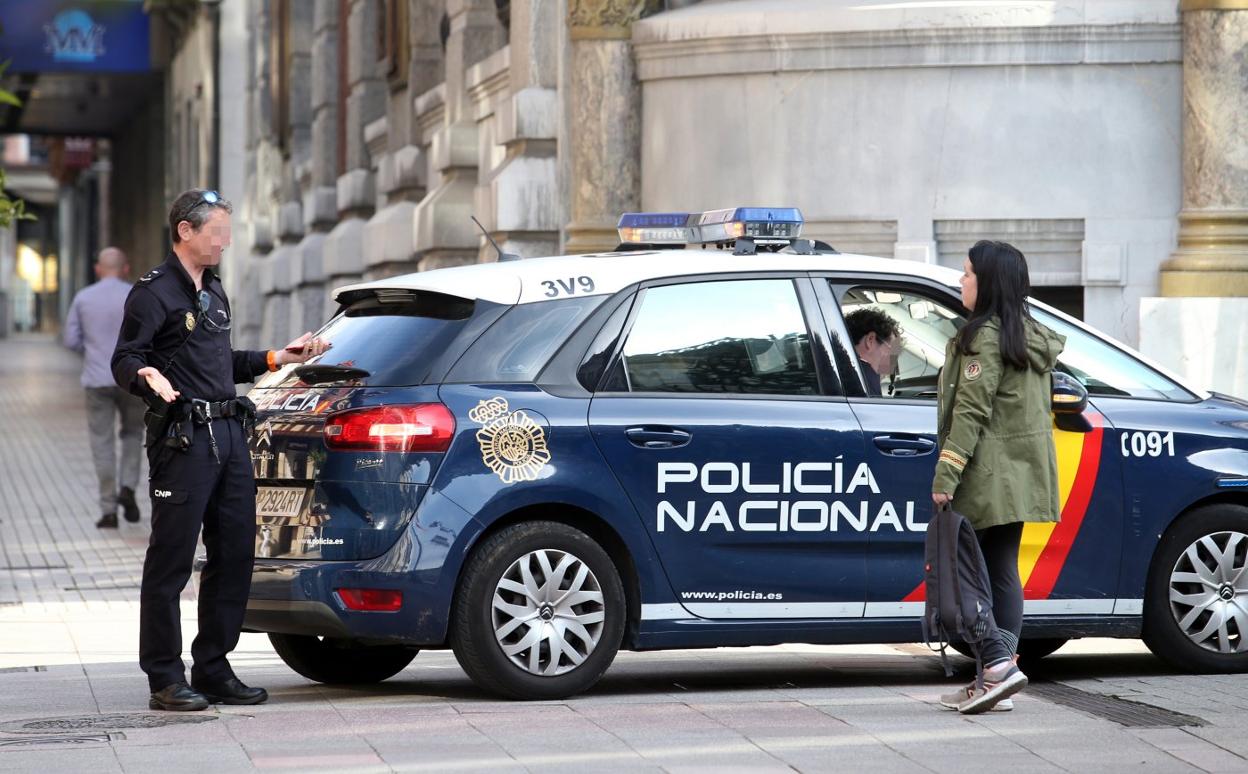 Agentes de la Policía Nacional sancionan a una joven en la calle Fruela, en Oviedo. 