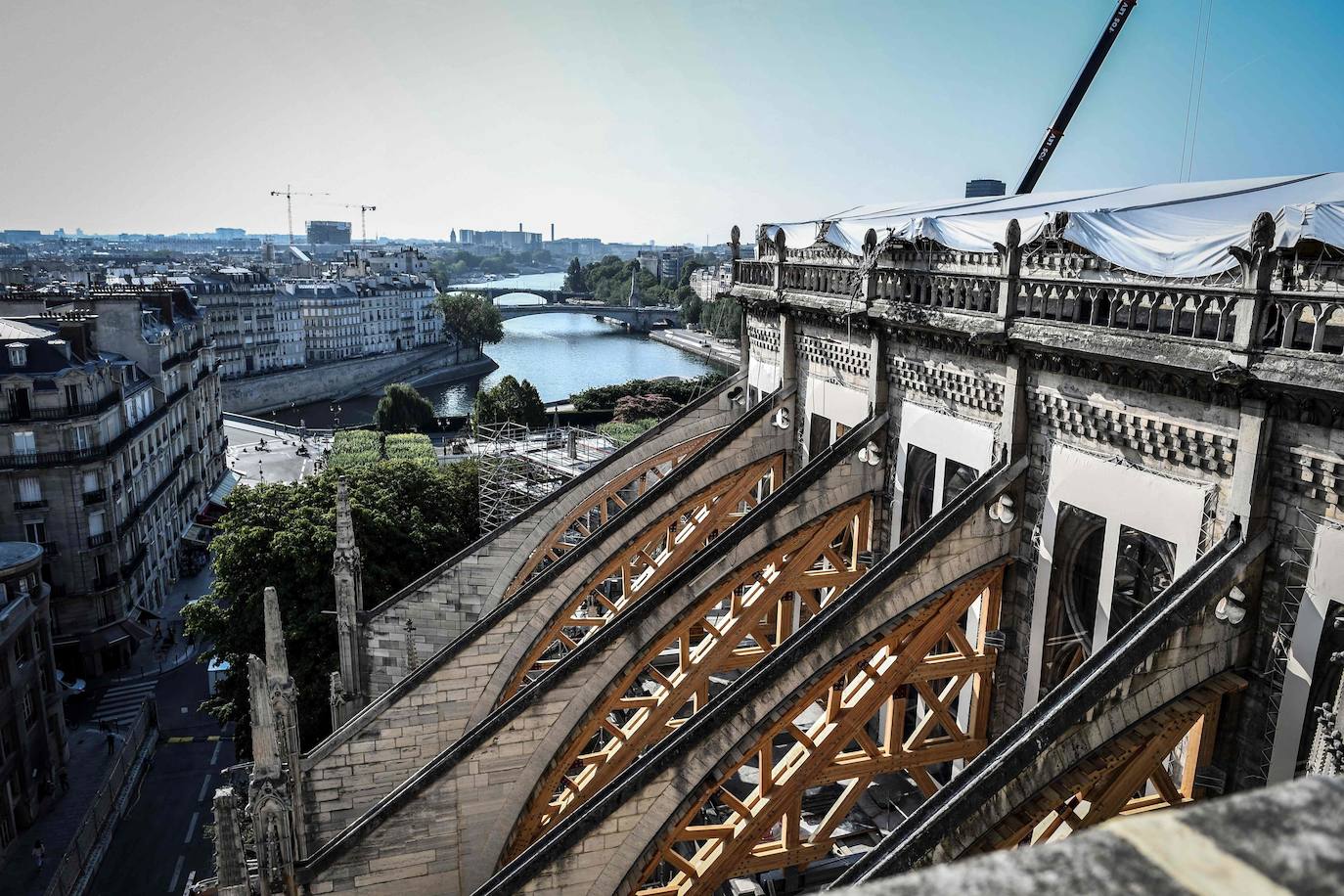 Ocho siglos de historia quedaron en suspenso cuando el 15 de abril de 2019 un incendio derribó la aguja de Notre Dame y su cubierta. Un año después, Francia persiste en su objetivo de reabrir la catedral en 2024, aunque el coronavirus mantenga paralizadas las obras. Las vallas que rodean el templo parisino, la grúa sin movimiento y los andamios que velan por su estructura son reflejo de aquella fatídica tarde, sobre la que la Justicia todavía no ha podido esclarecer el origen de las llamas. El avance de las pesquisas y de la restauración está determinado por la pandemia que ha puesto en hibernación al mundo. Aunque la investigación judicial prosigue en manos de la Brigada Criminal, el análisis técnico se vio frenado cuando este 16 de marzo las obras se suspendieron hasta nueva orden por precaución sanitaria.