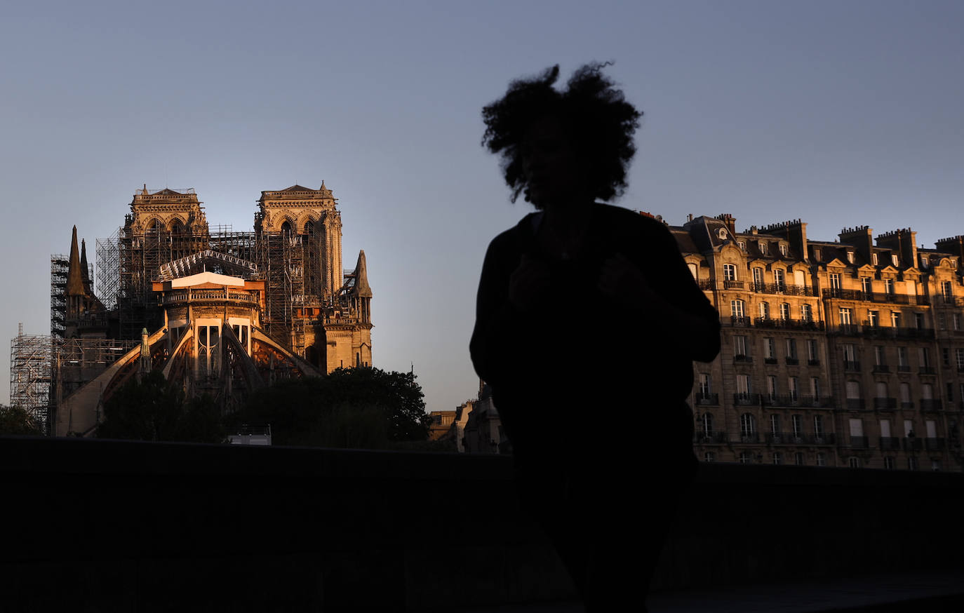 Ocho siglos de historia quedaron en suspenso cuando el 15 de abril de 2019 un incendio derribó la aguja de Notre Dame y su cubierta. Un año después, Francia persiste en su objetivo de reabrir la catedral en 2024, aunque el coronavirus mantenga paralizadas las obras. Las vallas que rodean el templo parisino, la grúa sin movimiento y los andamios que velan por su estructura son reflejo de aquella fatídica tarde, sobre la que la Justicia todavía no ha podido esclarecer el origen de las llamas. El avance de las pesquisas y de la restauración está determinado por la pandemia que ha puesto en hibernación al mundo. Aunque la investigación judicial prosigue en manos de la Brigada Criminal, el análisis técnico se vio frenado cuando este 16 de marzo las obras se suspendieron hasta nueva orden por precaución sanitaria.