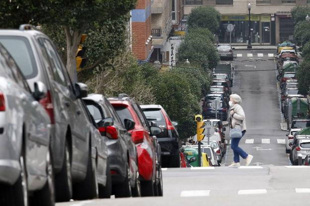 Una mujer cruza la calle Leopoldo Alas, de Gijón, casi desierta por el confinamiento. 