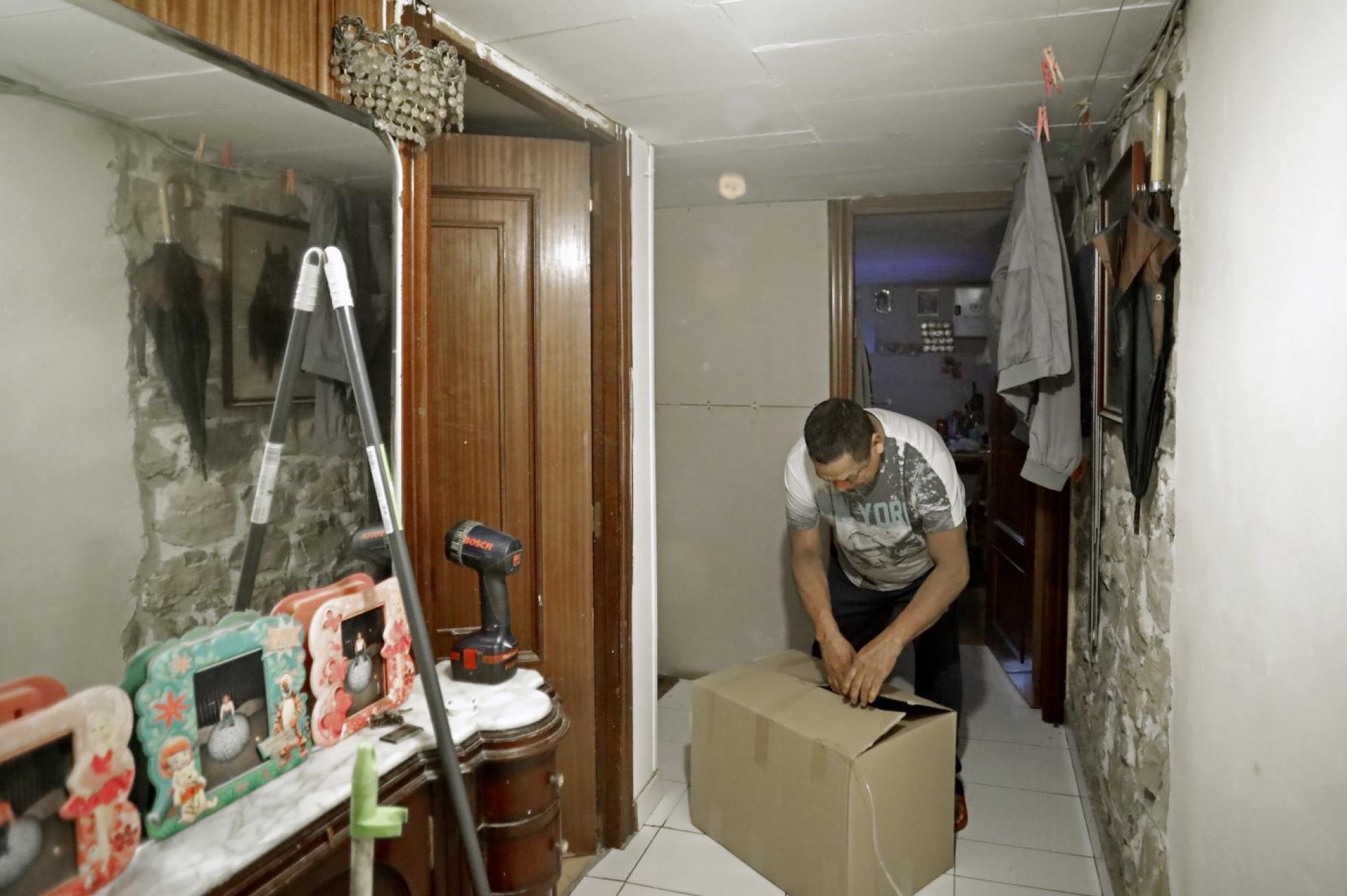 Flavio se dispone a abrir la caja con los productos de higiene básicos que cada veinte días le facilitan los voluntarios de Cruz Roja. 