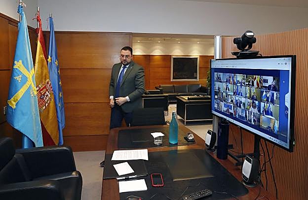 En la imagen el presidente asturiano, Adrián Barbón, antes de comenzar la videoconferencia. En el vídeo, información detallando en qué consiste el estado de alarma.
