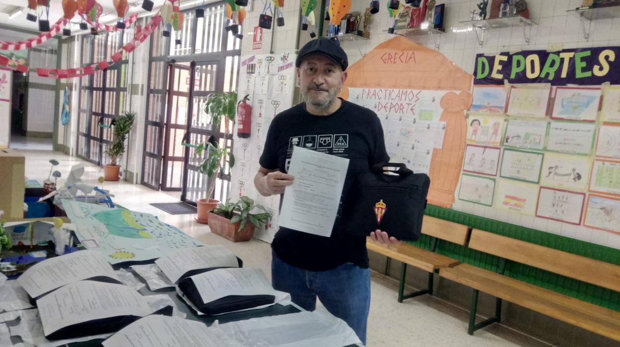 Felipe Fernández recoge un miniordenador en el colegio Asturias, de Gijón, préstamo del centro para su hijo, alumno de Primaria. 