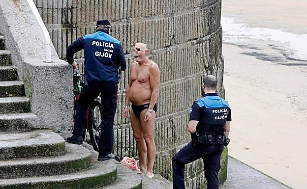 Los agentes de la Policía Local de Gijón intervienen ante la presencia del bañista en la Playa de San Lorenzo. 