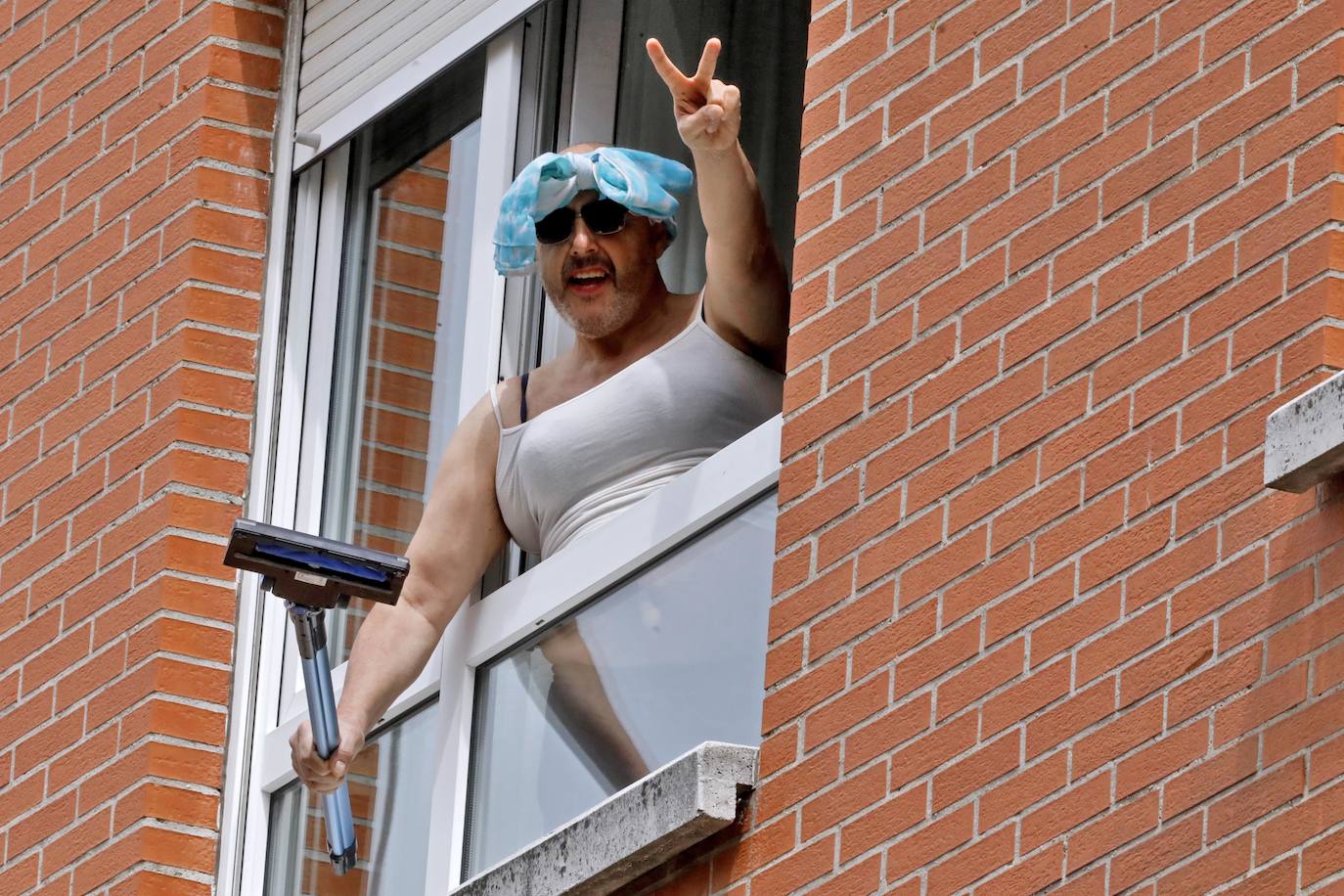 Vecinos del barrio de Contrueces se divierten este domingo desde sus ventanas emulando la estética del videoclip de Queen 'I want to break free'. 