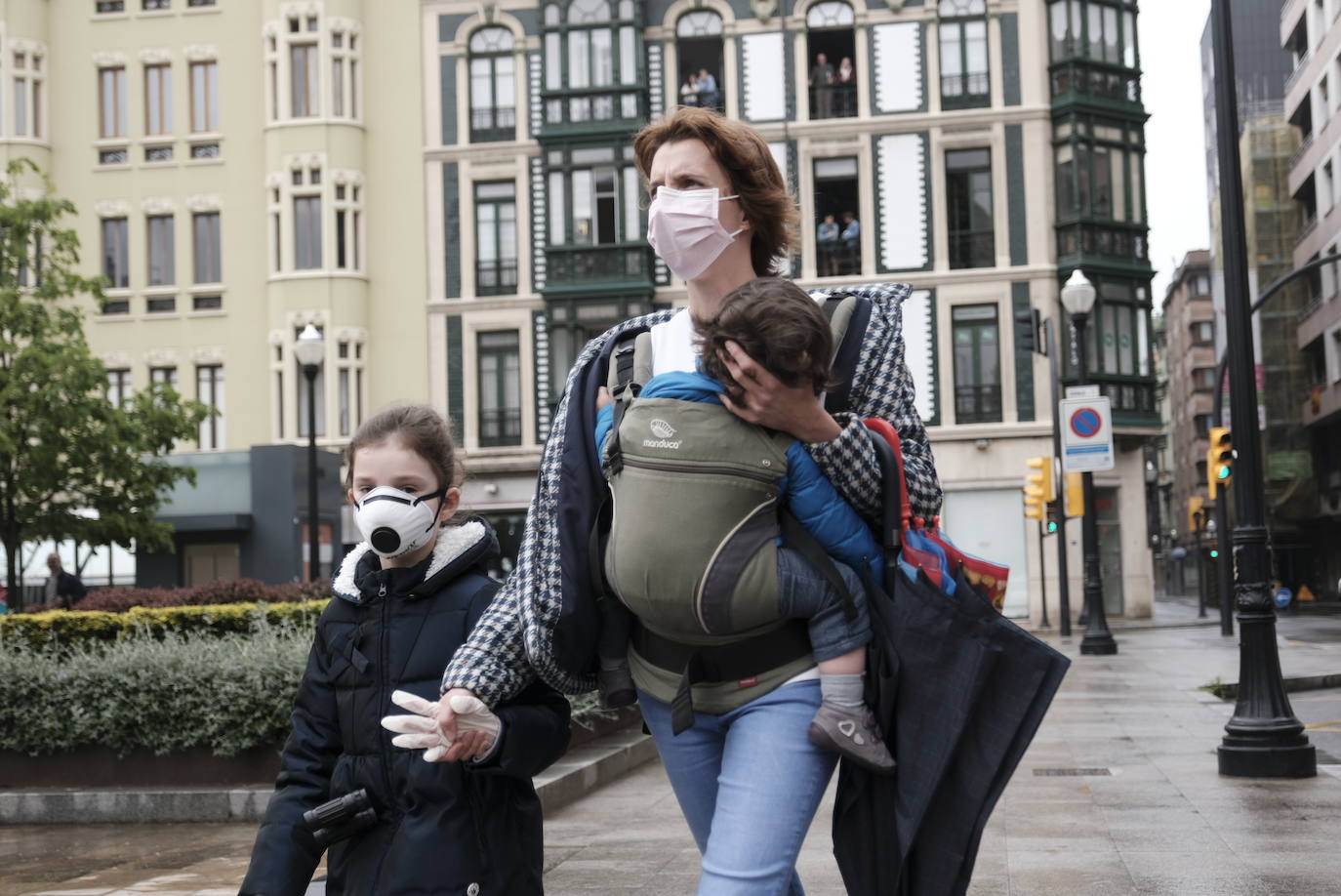 Primeros paseos bajo el orbayu en Gijón de los más pequeños