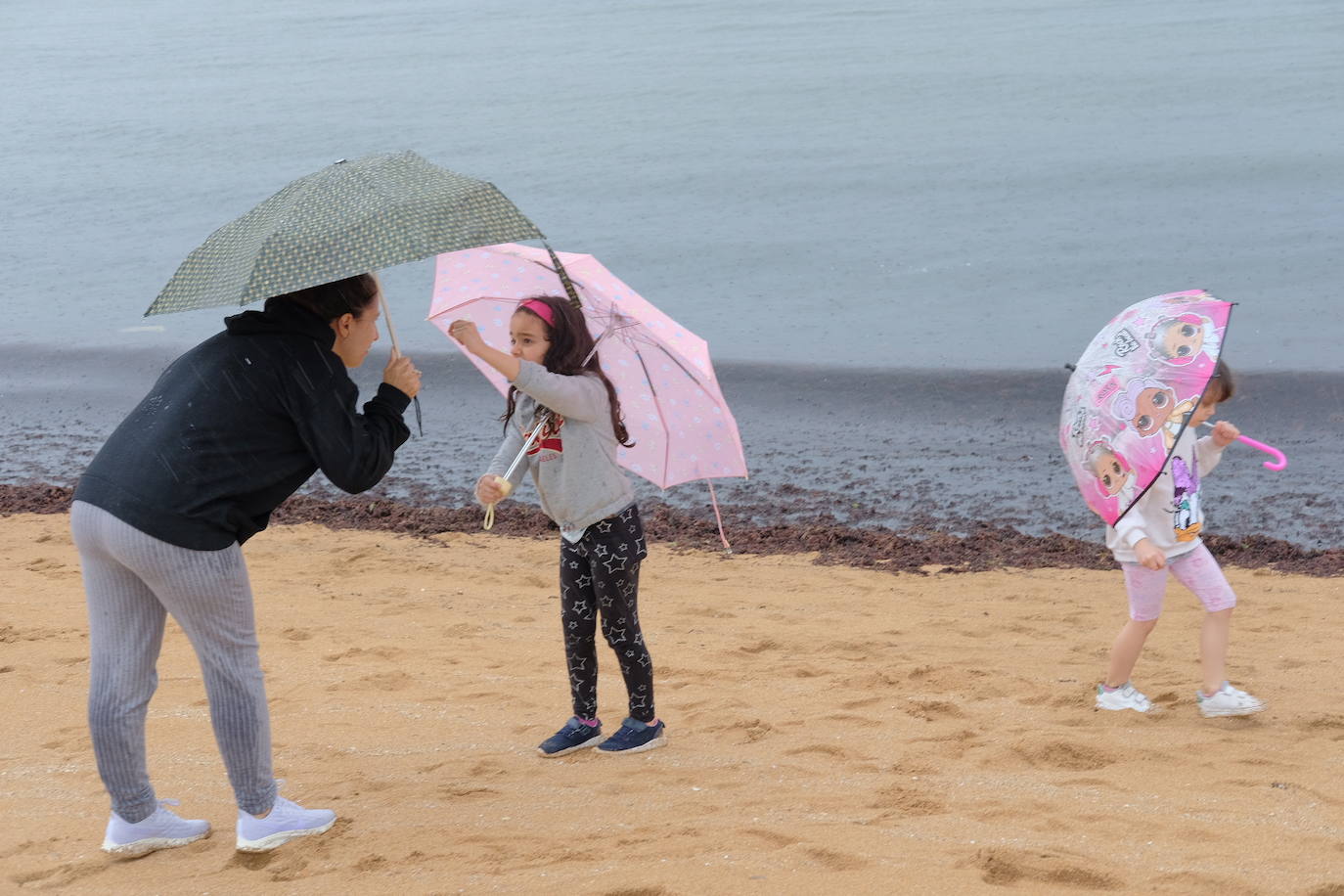 Primeros paseos bajo el orbayu en Gijón de los más pequeños