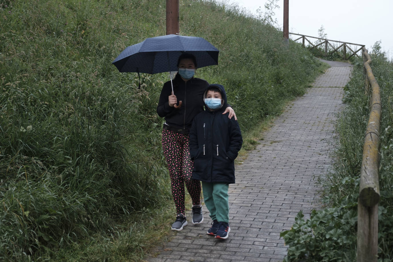 Primeros paseos bajo el orbayu en Gijón de los más pequeños