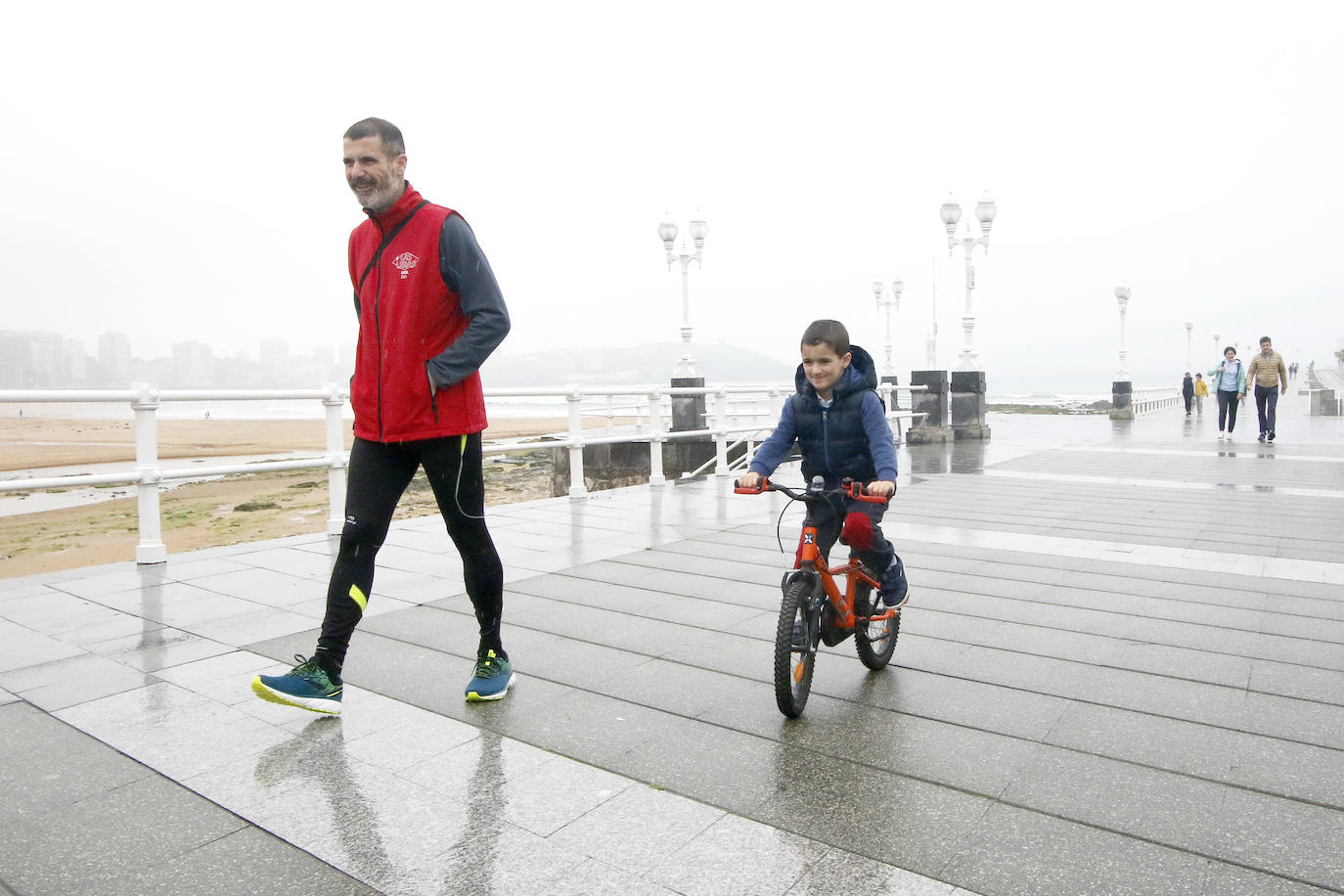 Primeros paseos bajo el orbayu en Gijón de los más pequeños