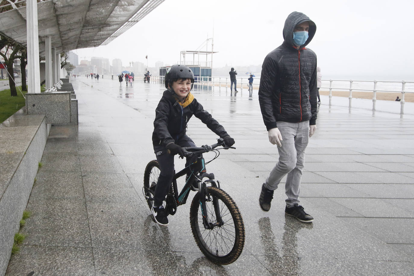 Primeros paseos bajo el orbayu en Gijón de los más pequeños