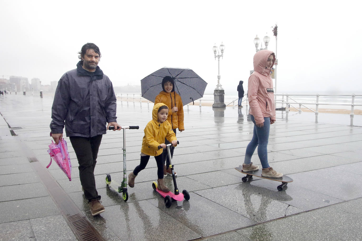 Primeros paseos bajo el orbayu en Gijón de los más pequeños