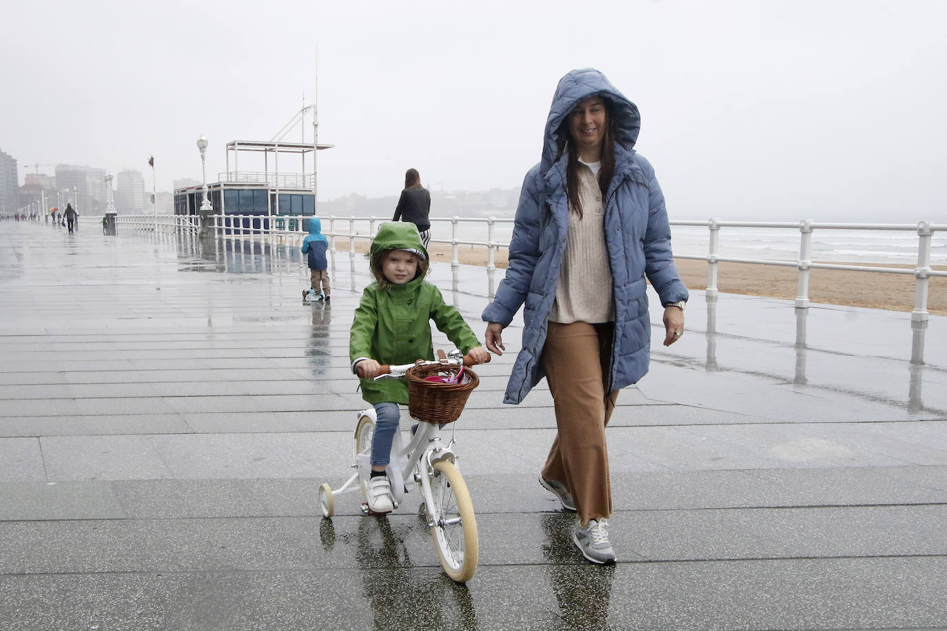 Primeros paseos bajo el orbayu en Gijón de los más pequeños