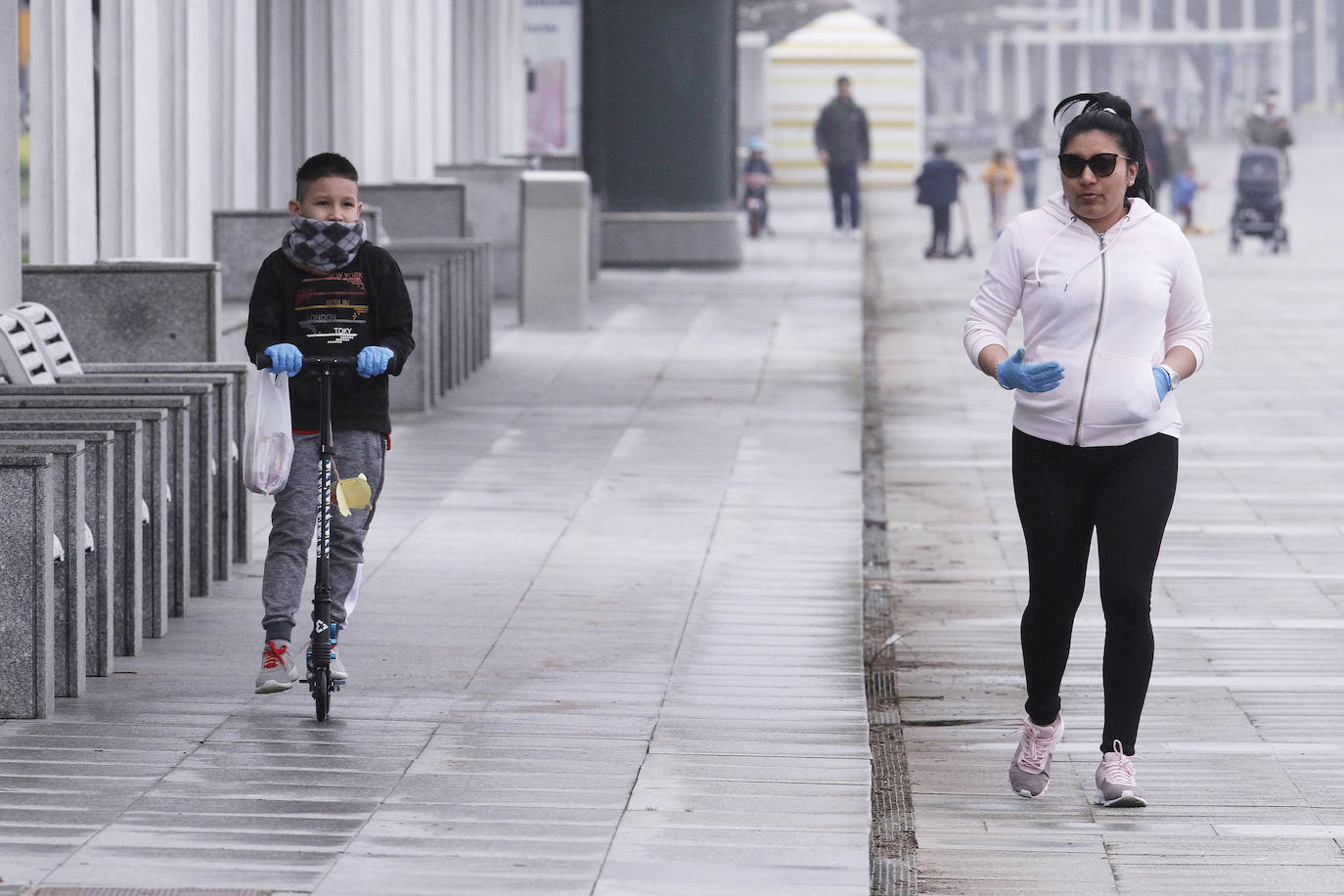 Primeros paseos bajo el orbayu en Gijón de los más pequeños