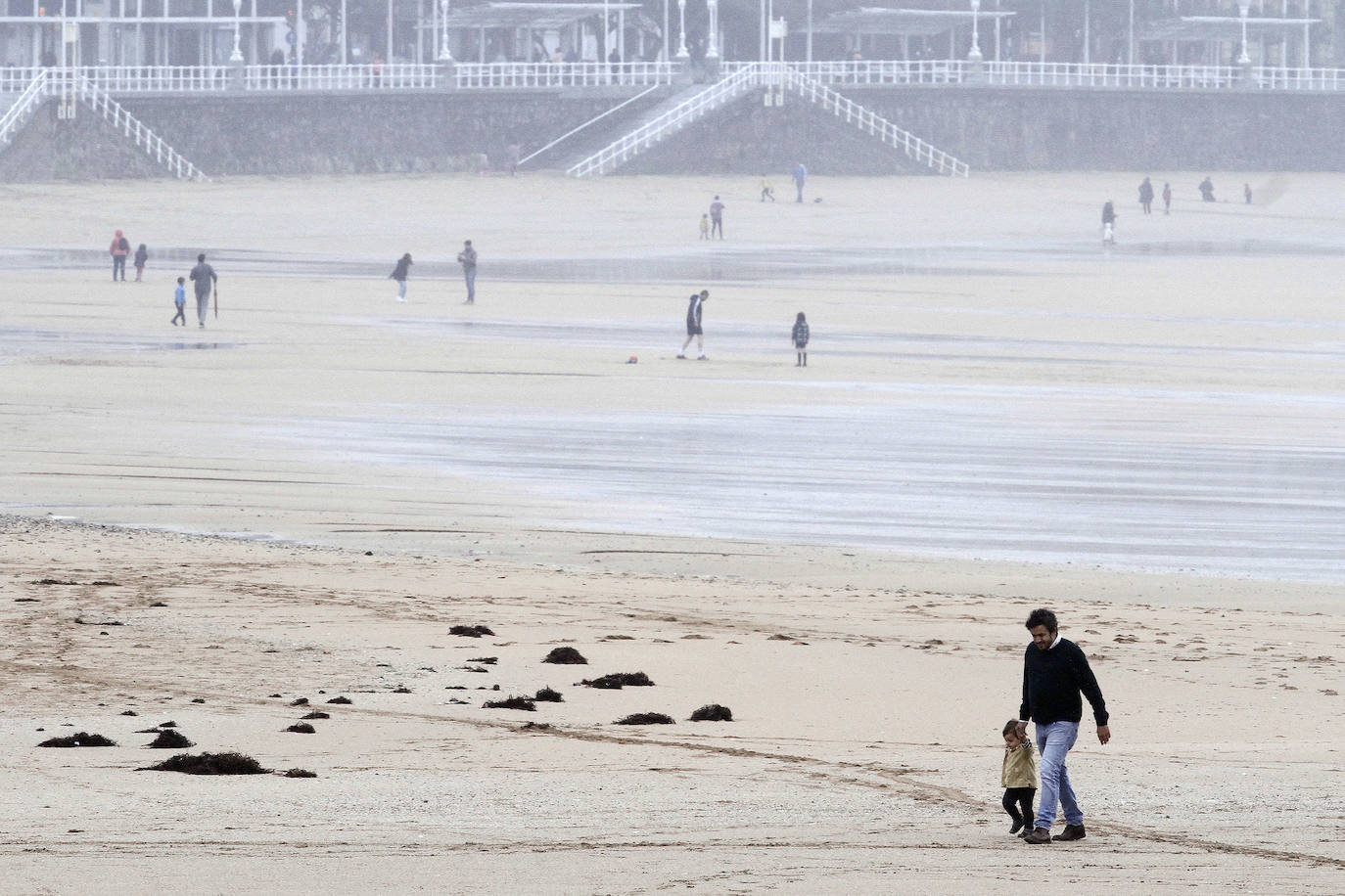 Primeros paseos bajo el orbayu en Gijón de los más pequeños