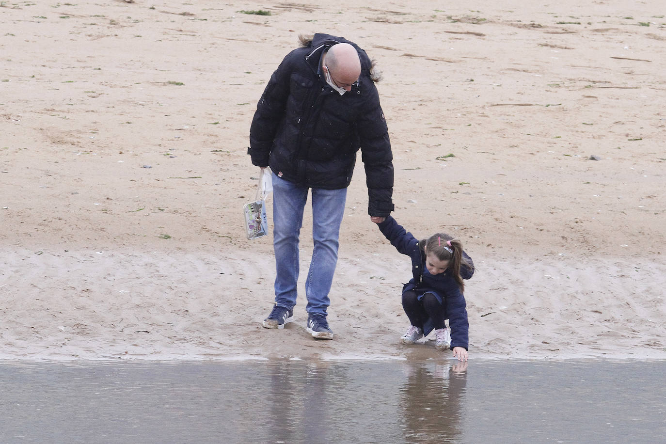 Primeros paseos bajo el orbayu en Gijón de los más pequeños