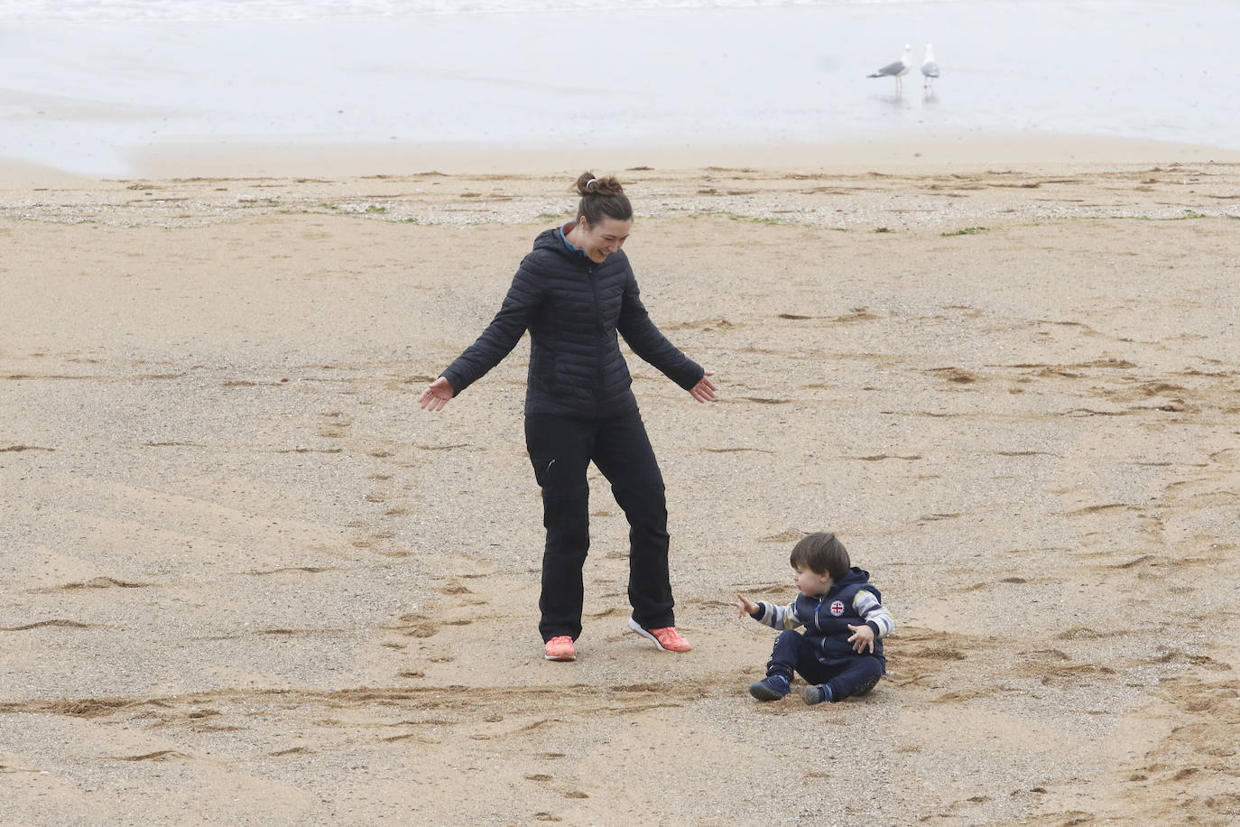 Primeros paseos bajo el orbayu en Gijón de los más pequeños