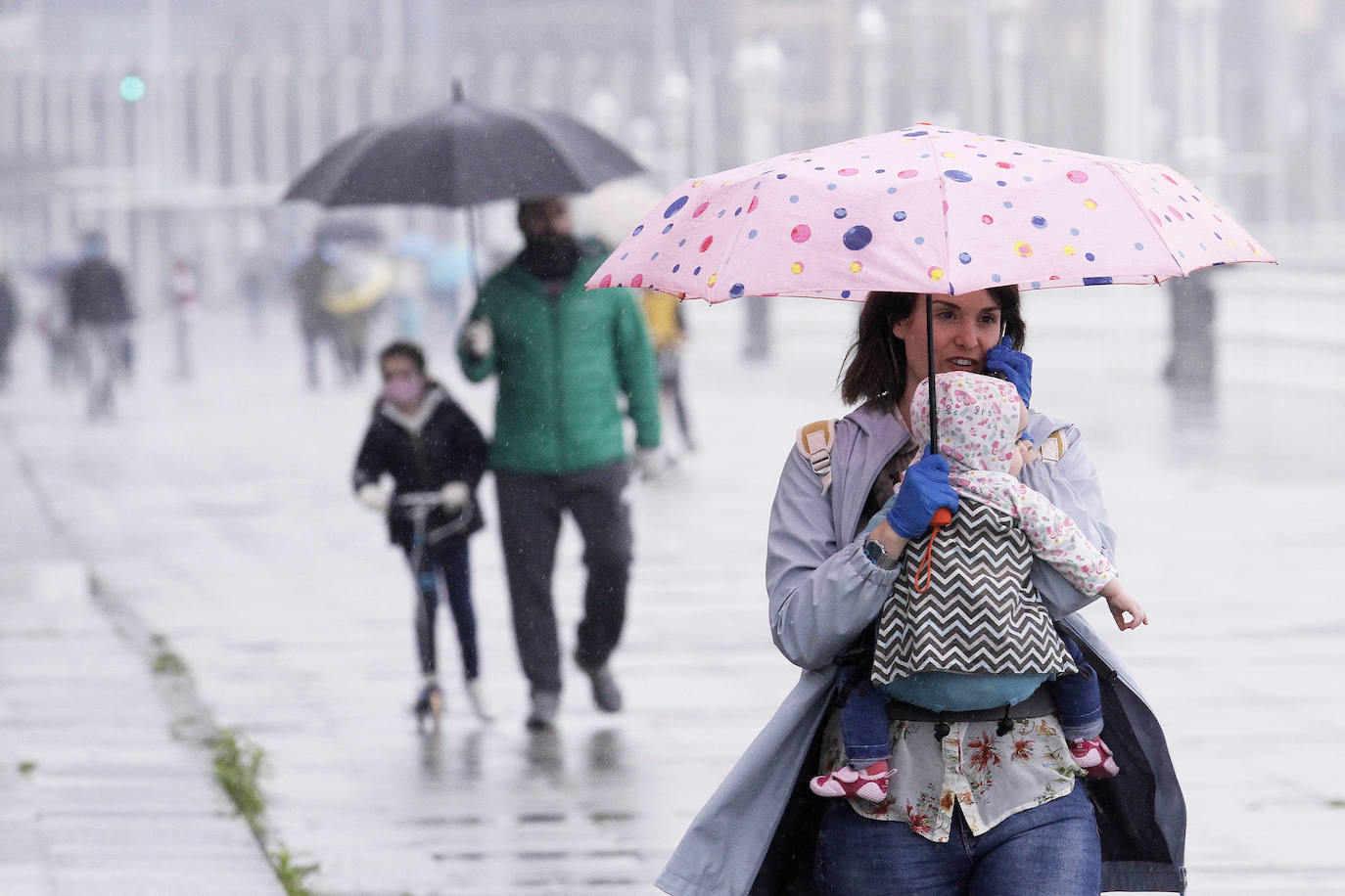 Primeros paseos bajo el orbayu en Gijón de los más pequeños