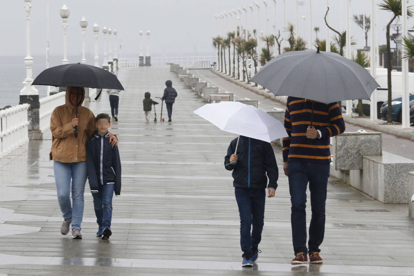 Primeros paseos bajo el orbayu en Gijón de los más pequeños