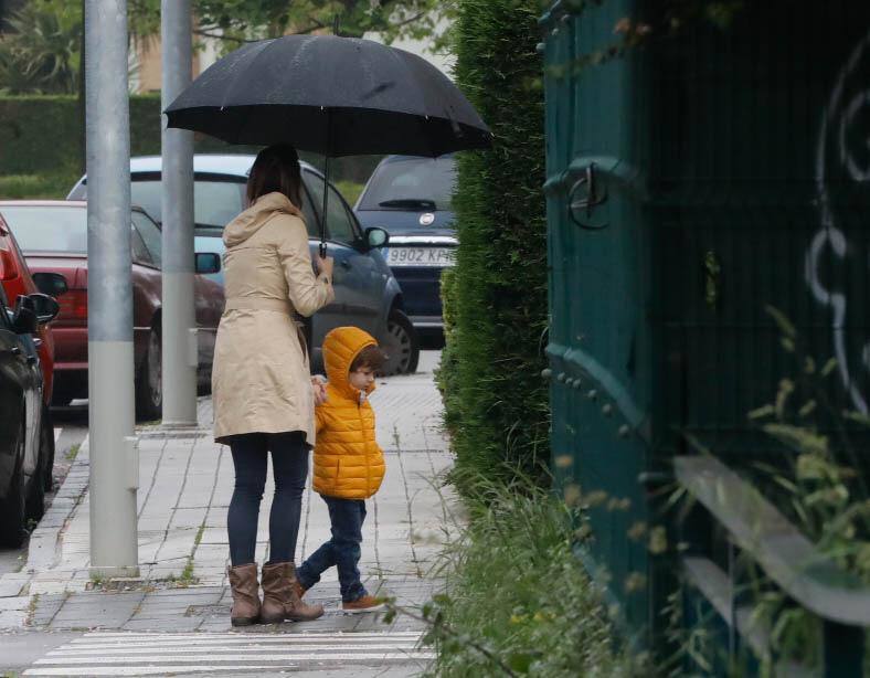 Primeros paseos bajo el orbayu en Gijón de los más pequeños