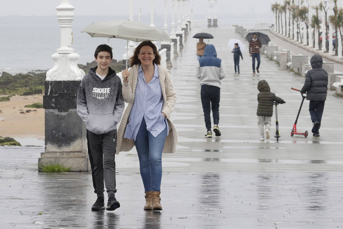 Primeros paseos bajo el orbayu en Gijón de los más pequeños