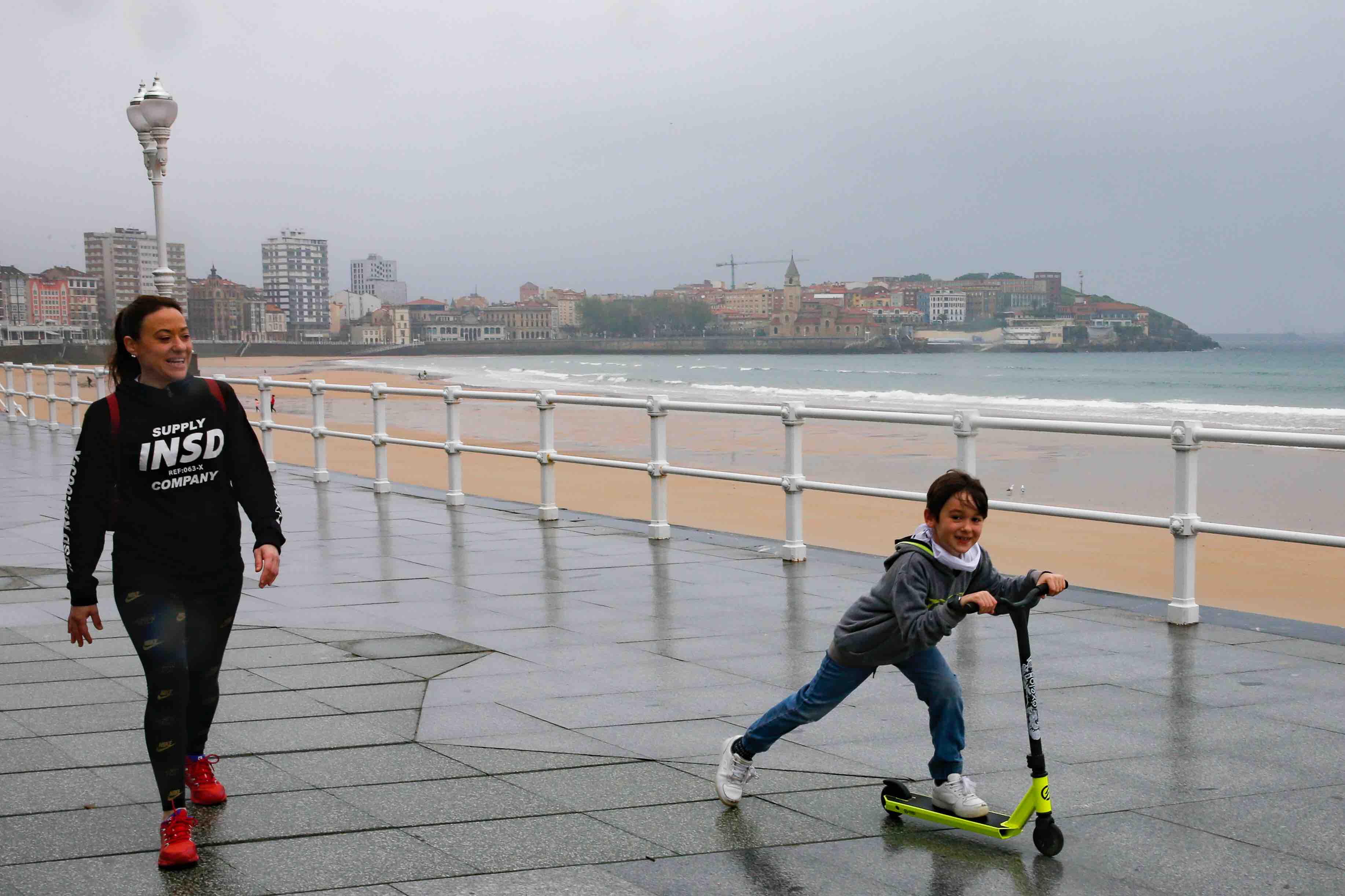 Primeros paseos bajo el orbayu en Gijón de los más pequeños