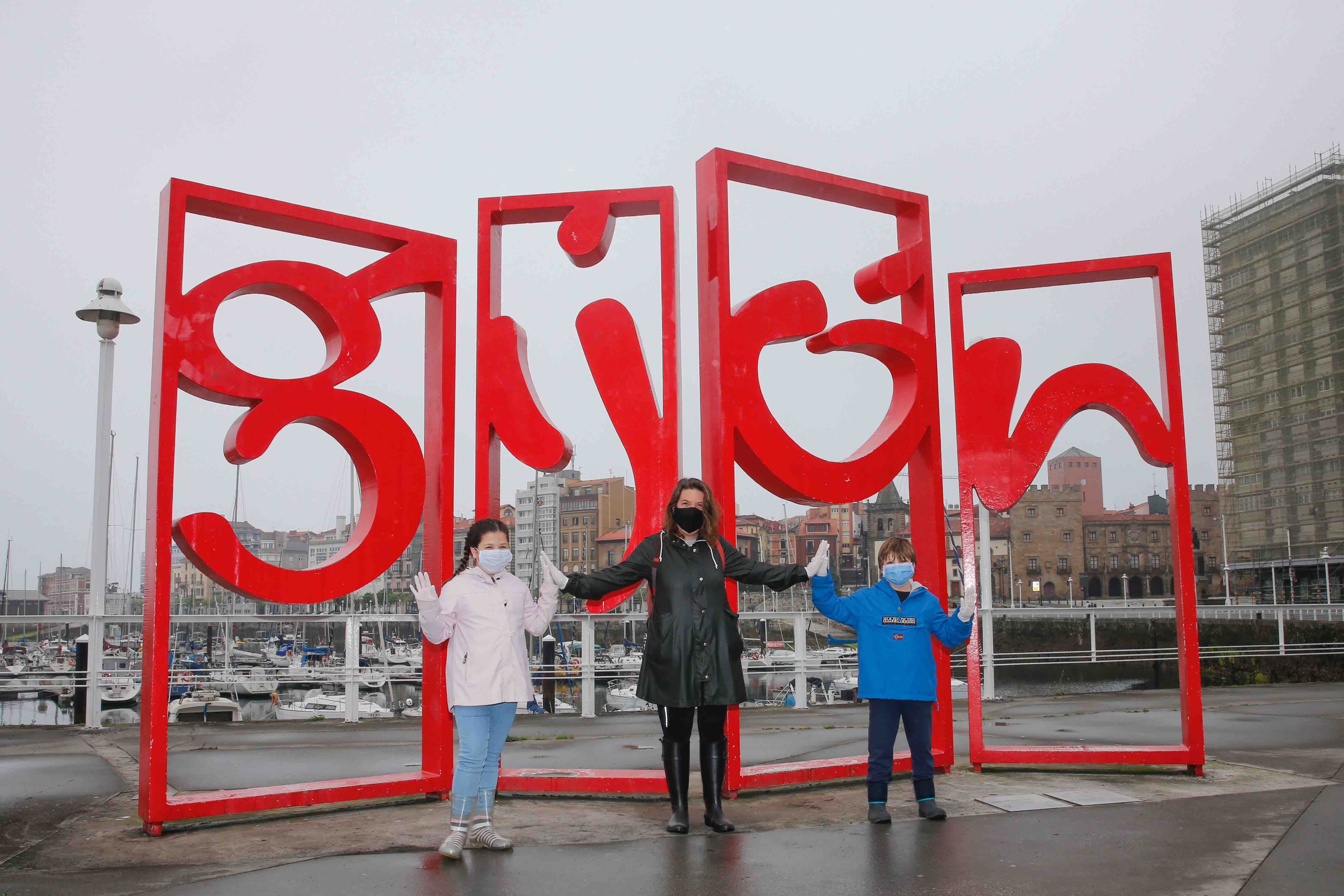 Primeros paseos bajo el orbayu en Gijón de los más pequeños