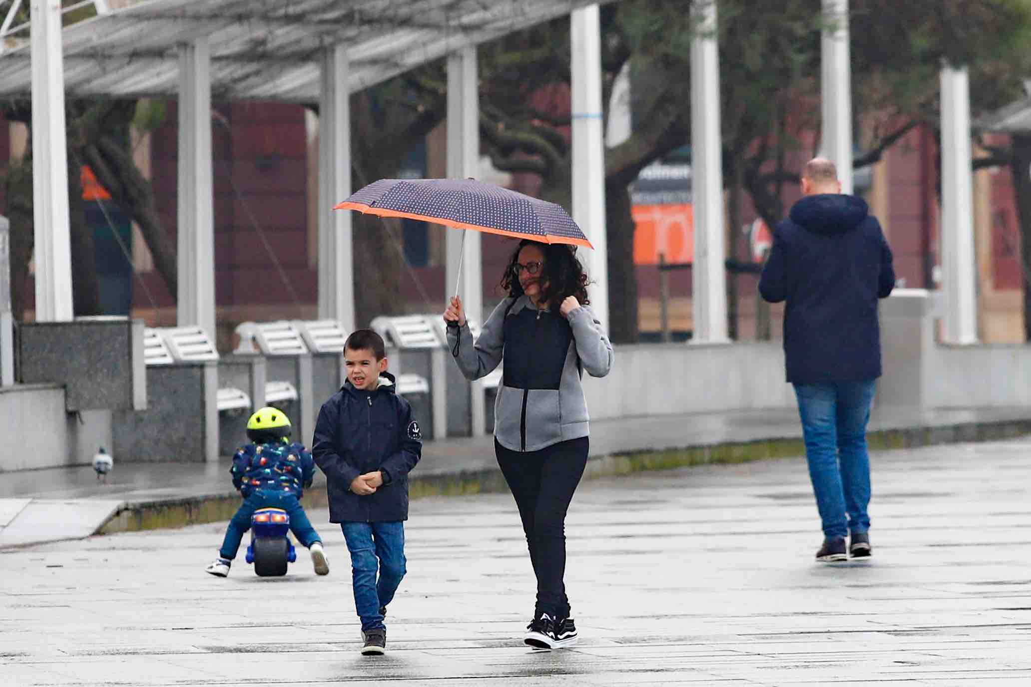 Primeros paseos bajo el orbayu en Gijón de los más pequeños