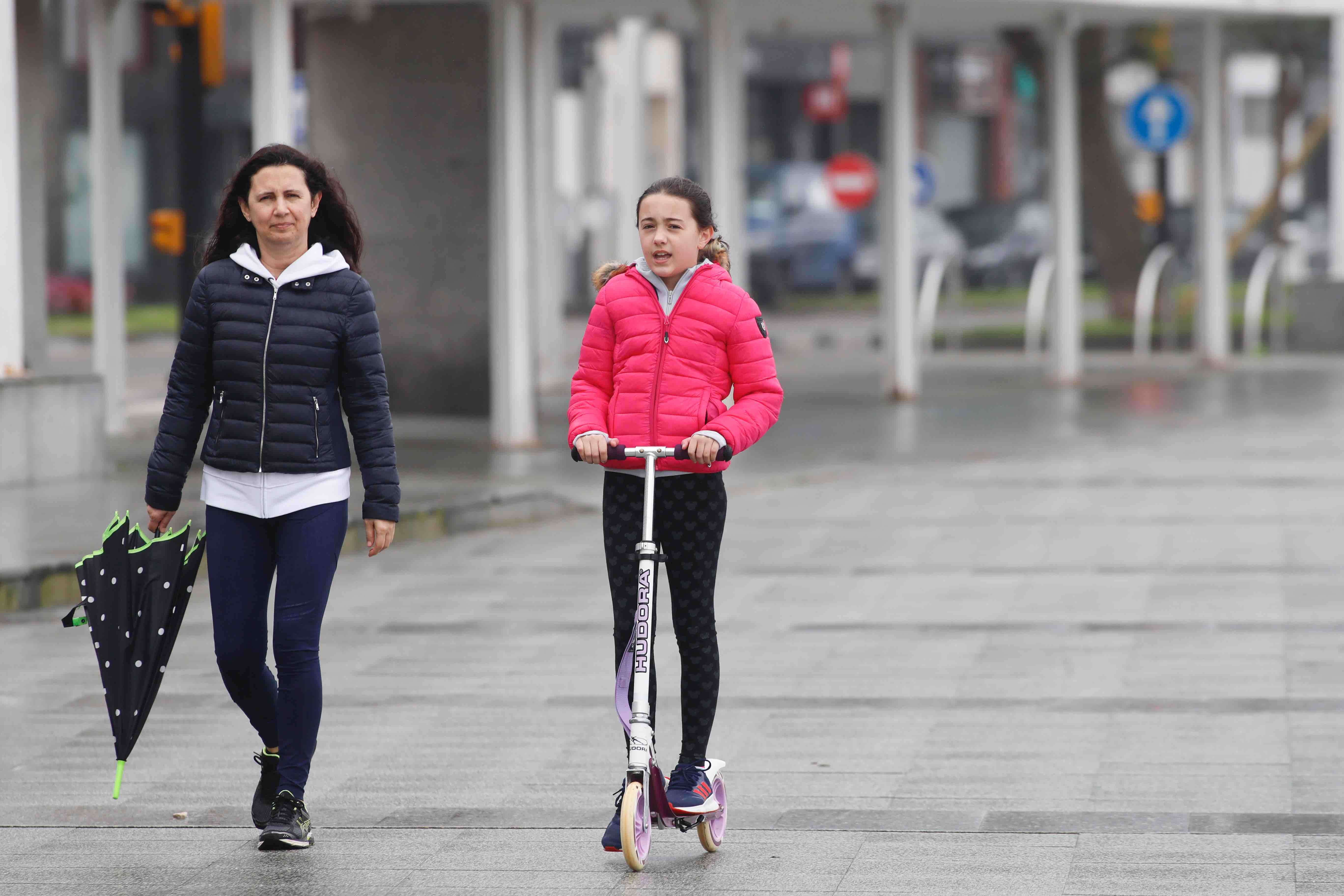 Primeros paseos bajo el orbayu en Gijón de los más pequeños