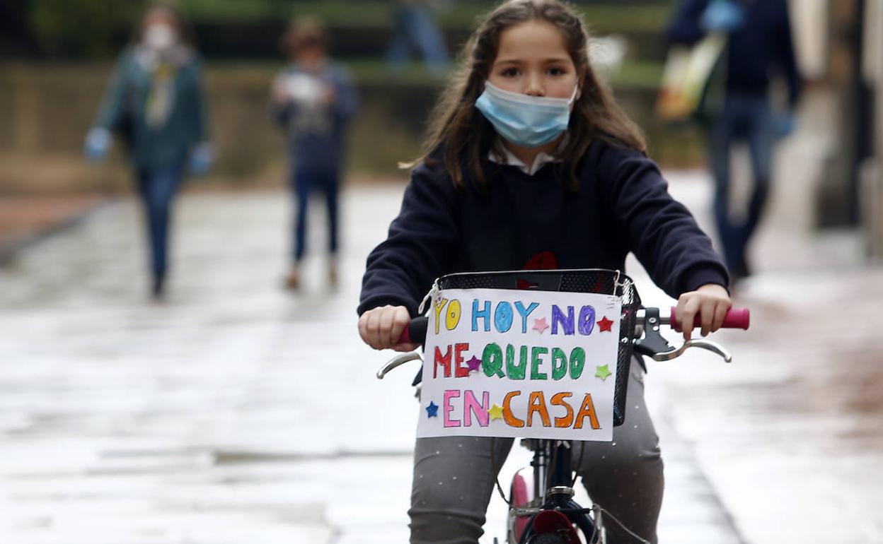 Una niña, en Oviedo, con su bicicleta, celebra el primer día de salida. 